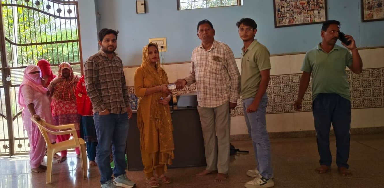 फोटो संख्या:63- मोहल्ला वाल्मीकि मंदिर में लाभार्थी को आभा कार्ड वितरित करते स्वास्थ्य विभाग की