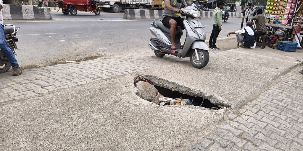 Commuting becomes hazardous on the highway due to a broken drain slab.