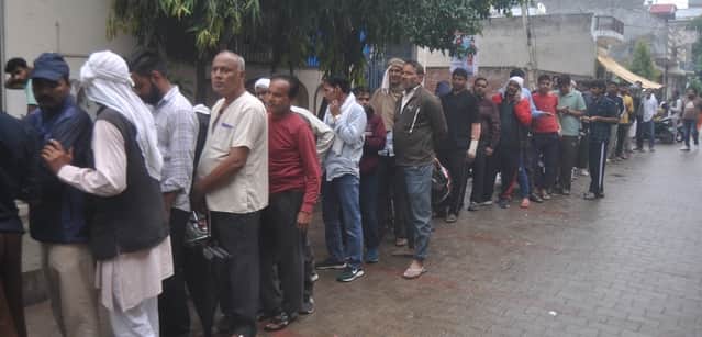 कवि नगर स्थित गैस एजेंसी के बाहर बूंदाबांदी में गैस की बुकिंग कराने के लिए लगी लोगों की लाइन । 
