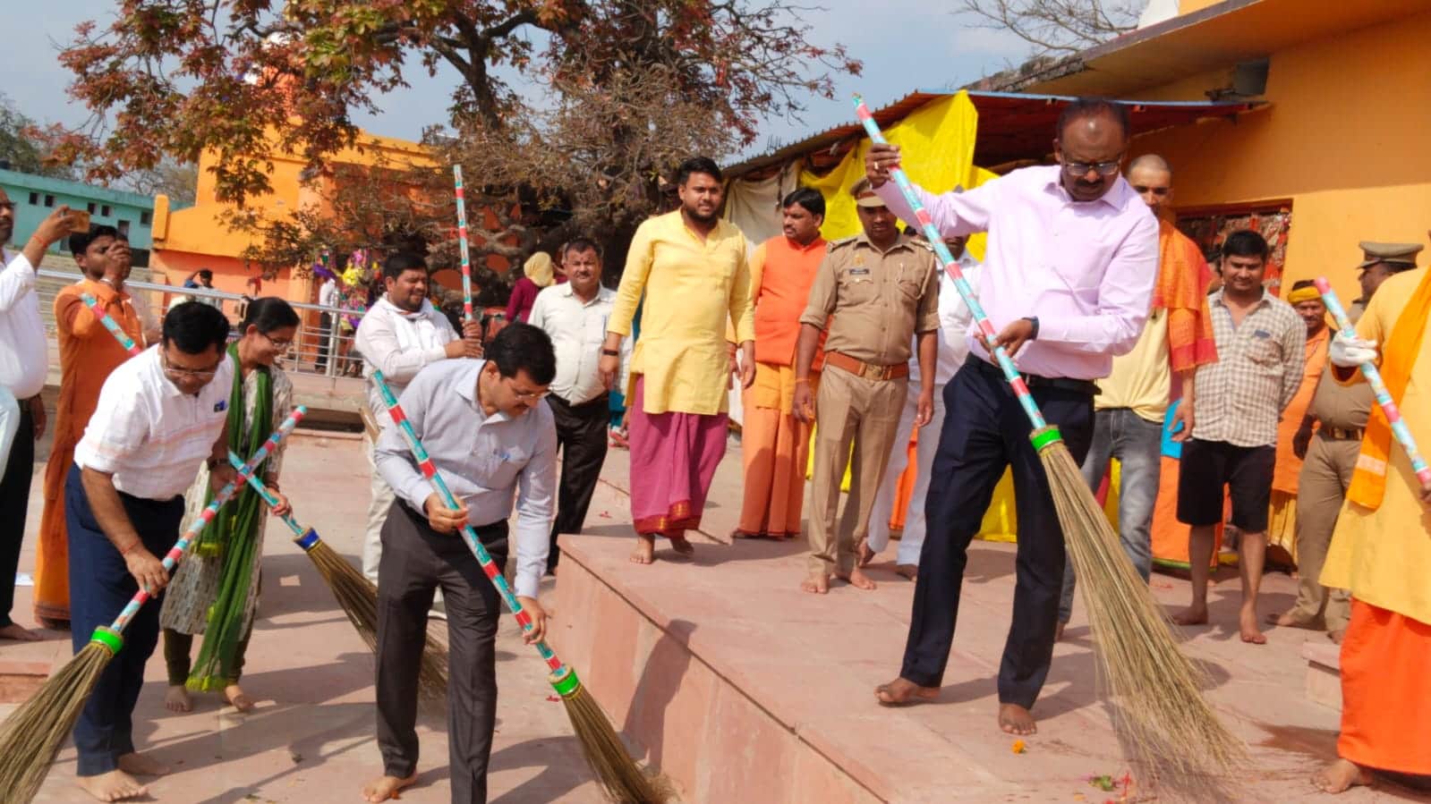 लेहड़ा मंदिर परिसर में झाडू़ लगाते डीएम संतोष शर्मा। 