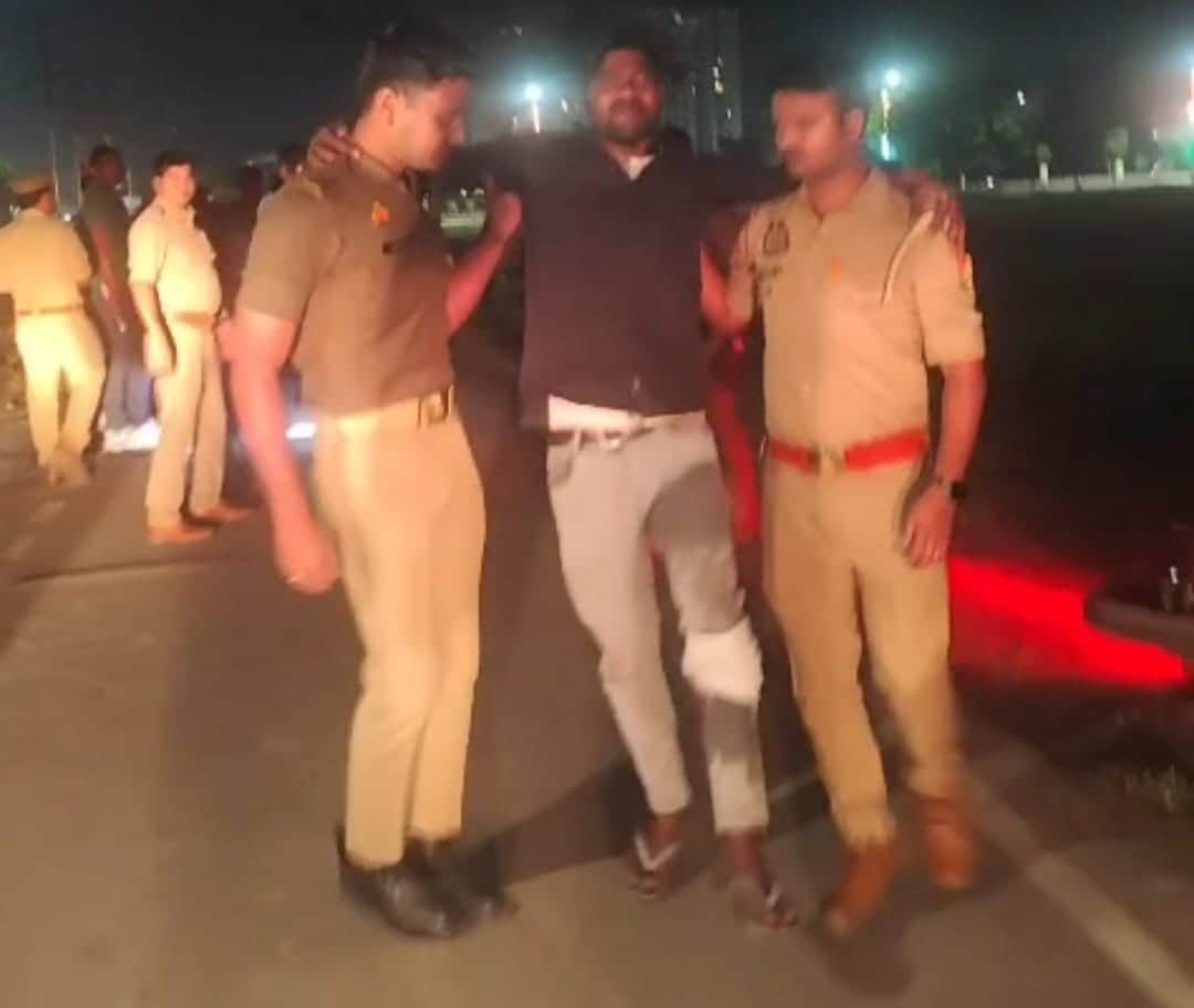 मुठभेड़ में घायल आरोपी ले जाती पुलिस।