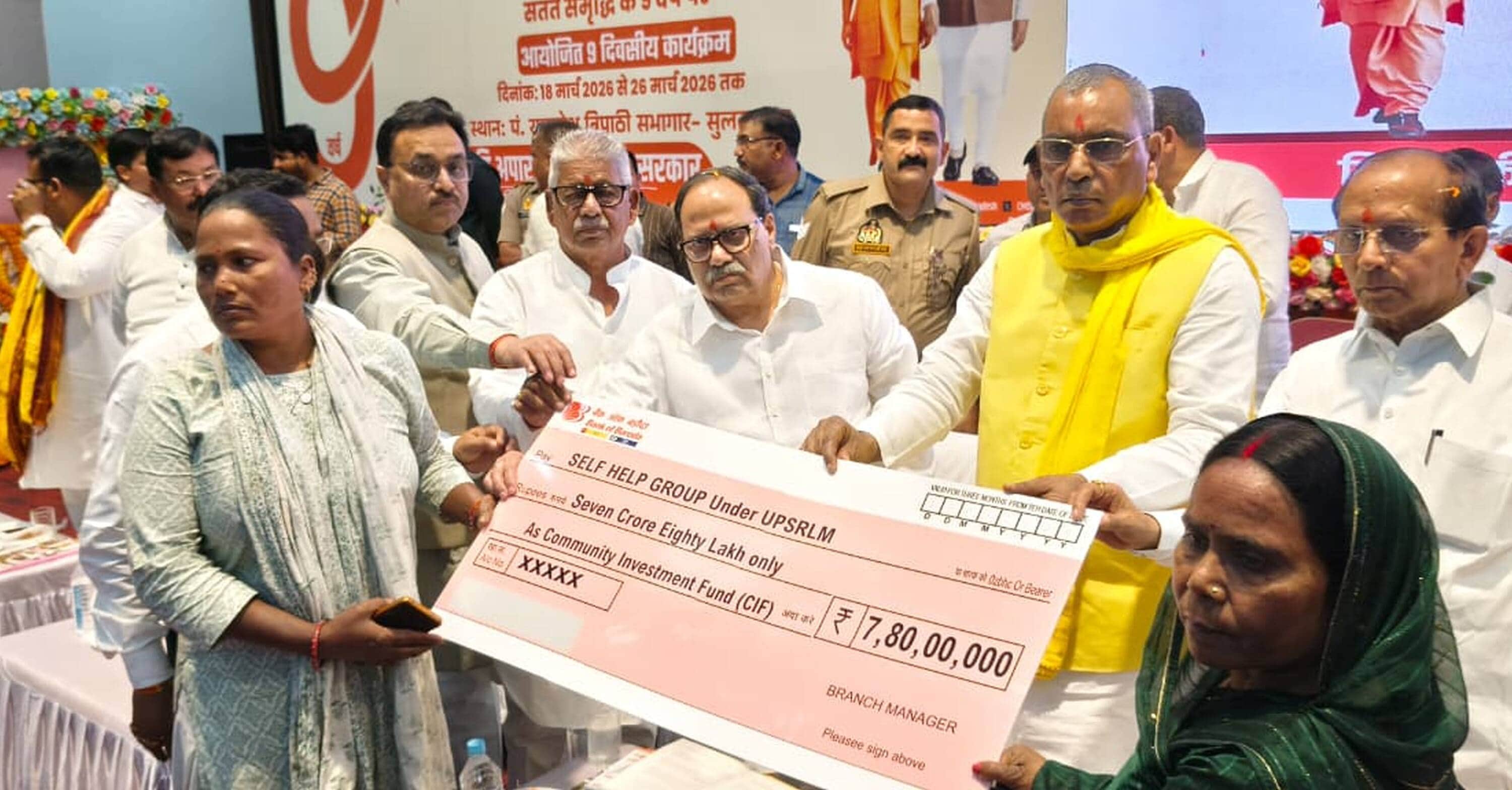  पं. राम नरेश त्रिपाठी सभागार में लाभार्थी को प्रतीकात्मक चेक देते प्रभारी मंत्री ओम प्रकाश राज