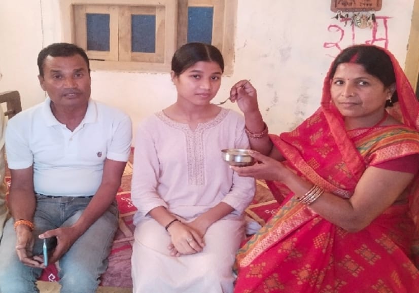 स्वीटी को मिठाई खिलाते परिजन
