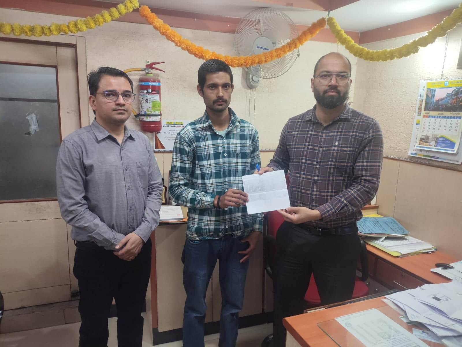 ददाहू में मृतक के पुत्र को दो लाख रुपये की सहायता प्रदान करते बैंक कर्मी। संवाद