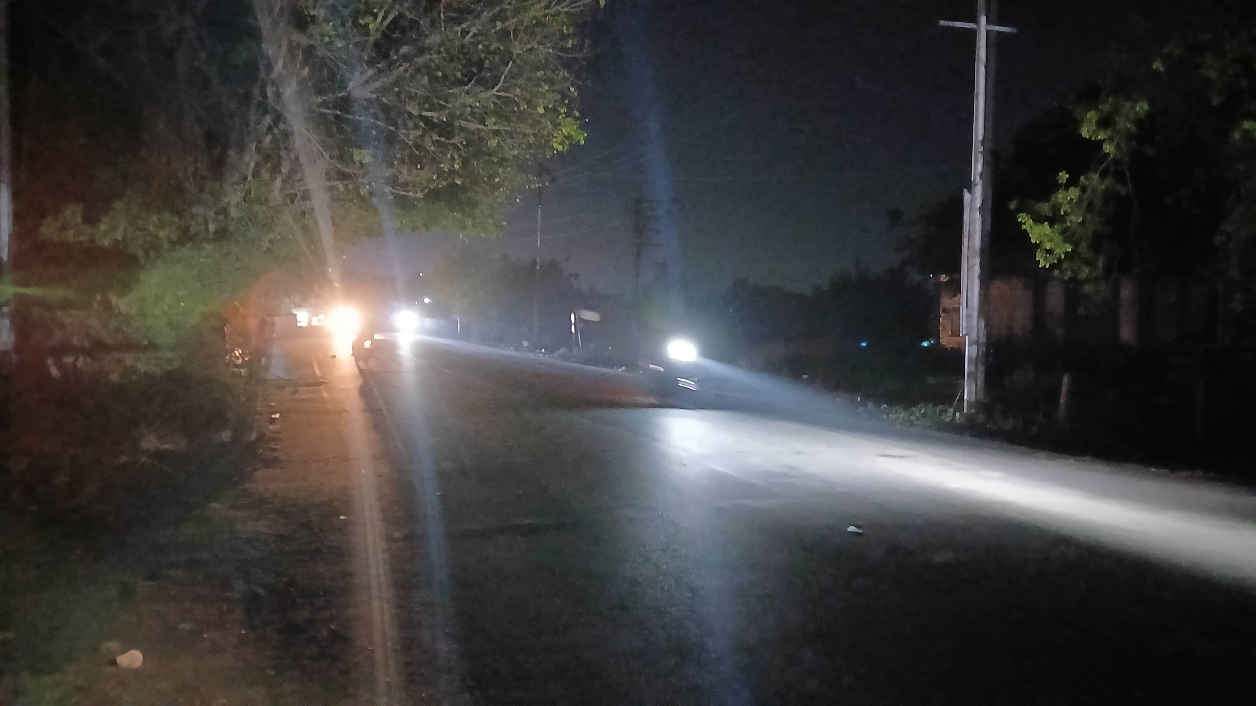 देवी रोड पर अंधेरे में से गुजरते वाहन। संवाद