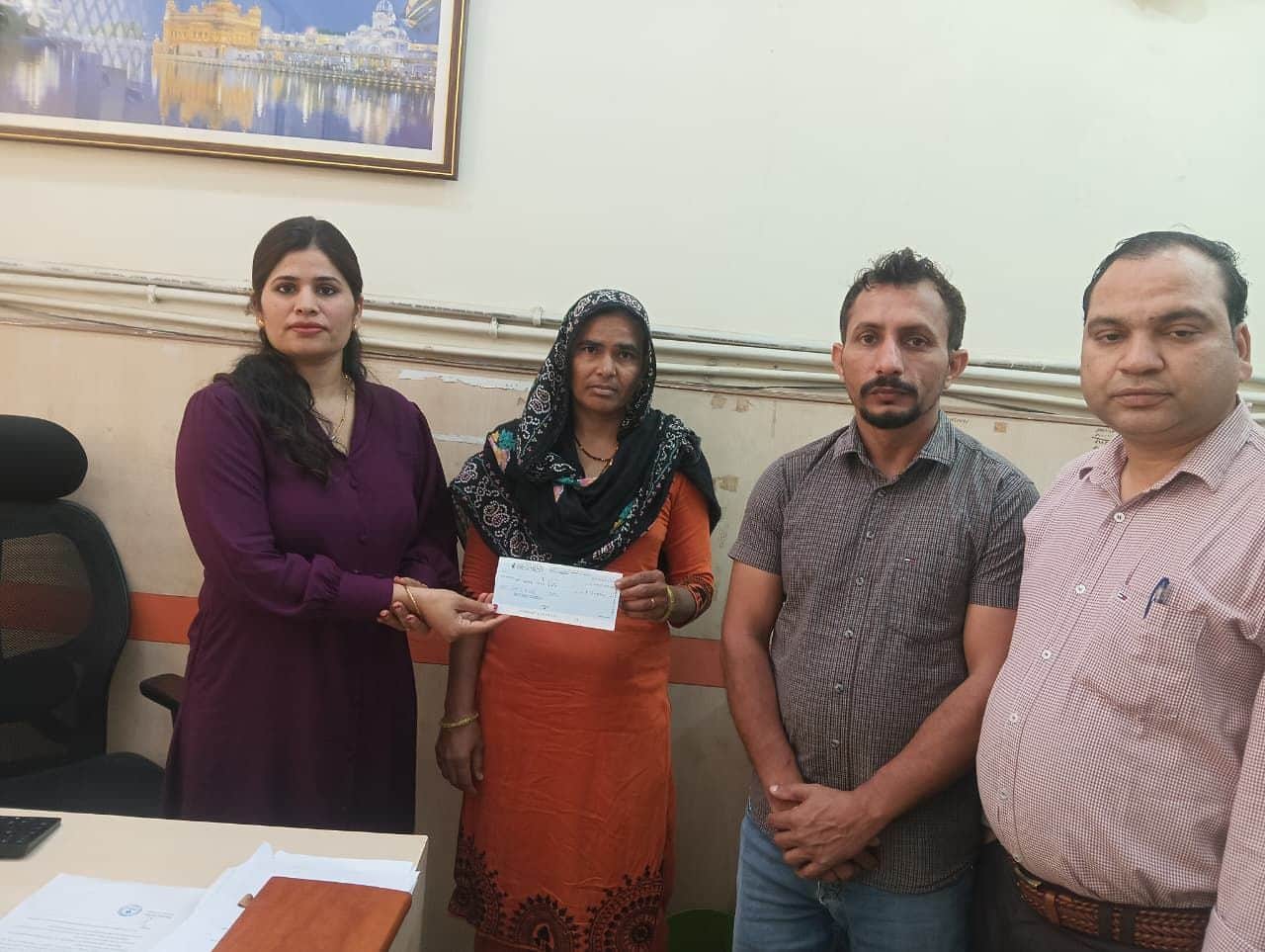 24जेएनडी01: पीड़ित परिवार को आर्थिक सहायता के लिए चेक सौंपते हुए बैंक प्रबंधक विशाखा। स्रोत : 