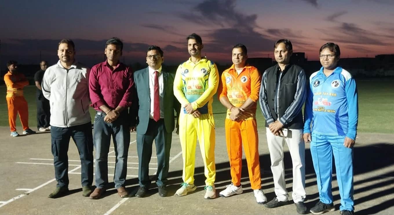 क्रिकेट मैच से पहले मैदान पर टॉस करने के लिए अतिथि के साथ खड़े टीम के कप्तान।स्रोत एसोसिएशन