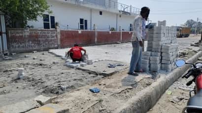 नई अनाज मंडी में सड़क पर ब्लाक बिछाते श्रमिक। संवाद