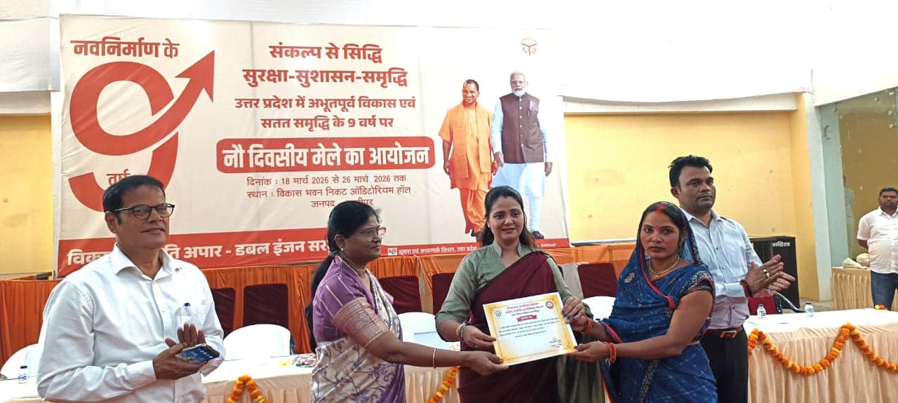 ऑडिटोरियम हॉल में समूह की महिला को प्रमाण पत्र देतीं जिला पंचायत अध्यक्ष सपना सिंह और नगर पालिक