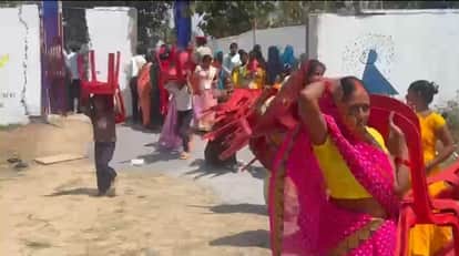 पंडाल में बैठने के लिए कुर्सियां ले जाती महिलाएं