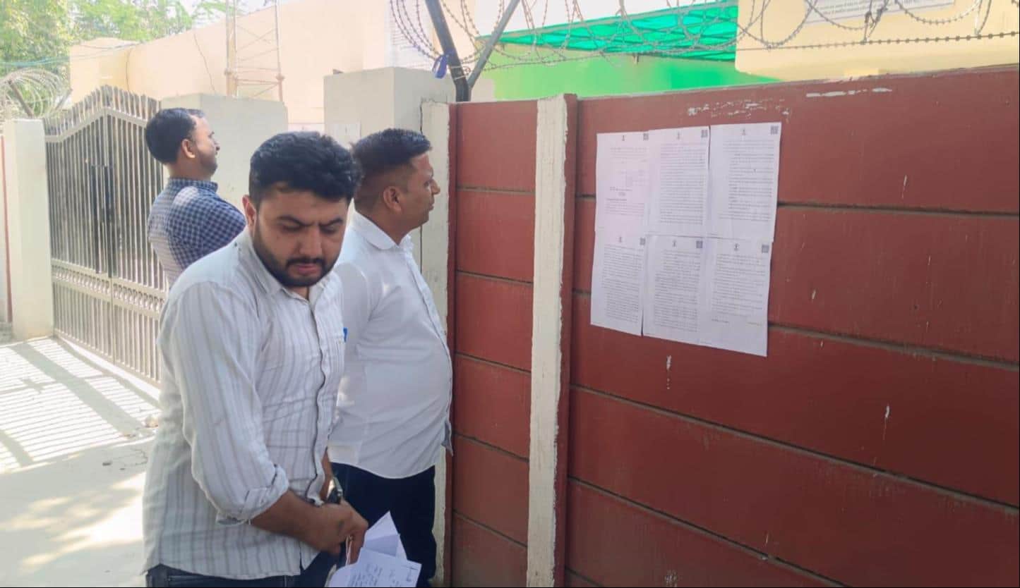 बीएसटी कॉलोनी में क्वार्टरों पर चिपके नोटिस देखते वहां के निवासी। संवाद