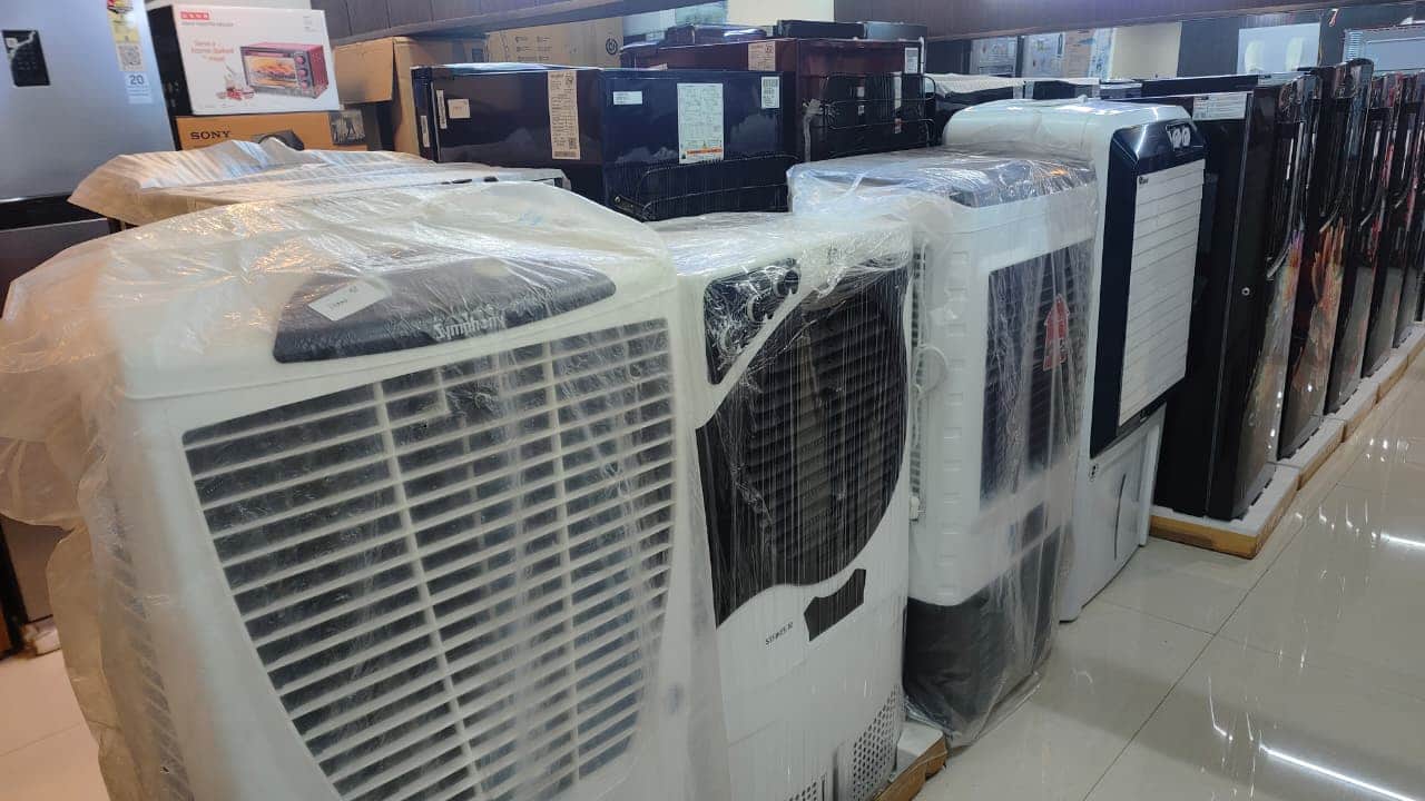 बाजार में शोरूम पर रखे कूलर, फ्रिज आदि। संवाद