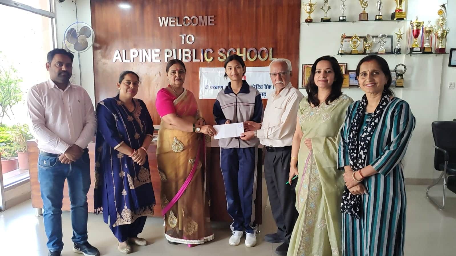 फोटो कैप्शन: सौम्या को नकद पुरस्कार देते हुए बैंक प्रबंधक तथा स्कूल निदेशक प्रेम जोशी।