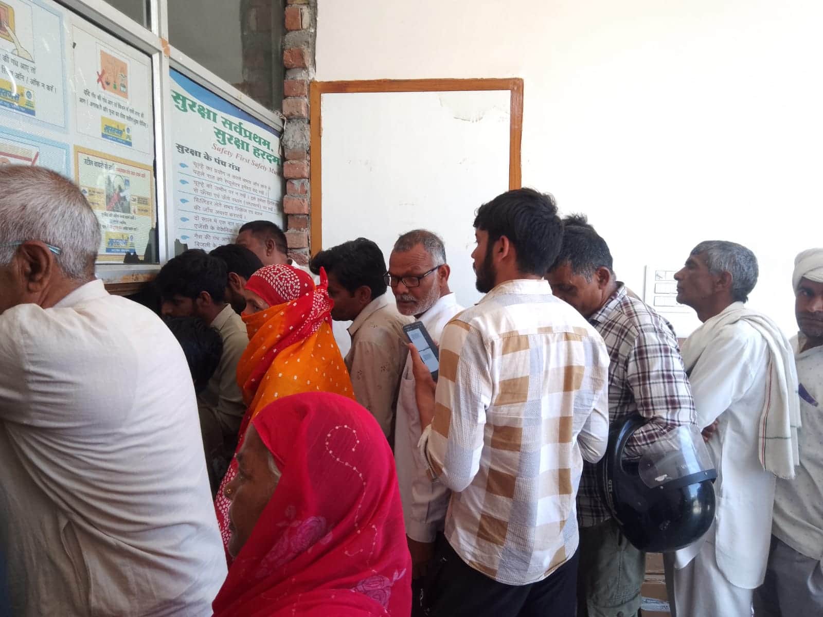 फोटो नंबर- 07पर्ची कटवाने के लिए एजेंसी के बाहर लाइन में लगे लोग। संवाद