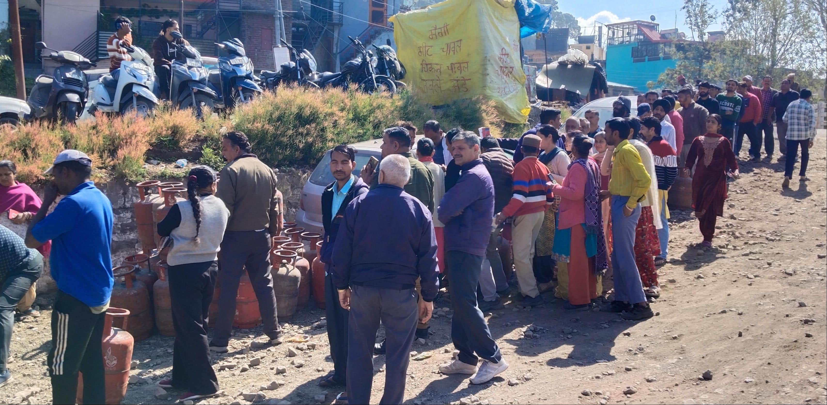 गैस सिलिंडर के लिए धर्मपुर में लगी लोगों कर कतार। संवाद