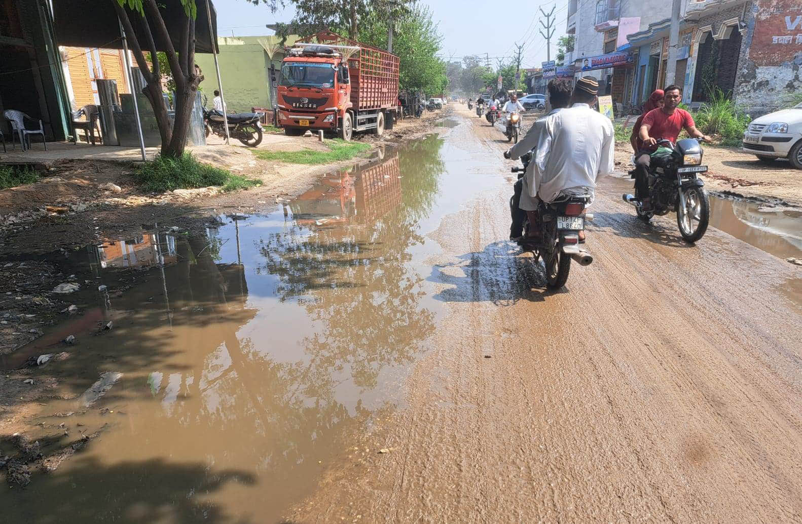 हरौड़ा रोड पर जलभराव और कींचड़ के बीच से गुजरते राहगीर। संवाद