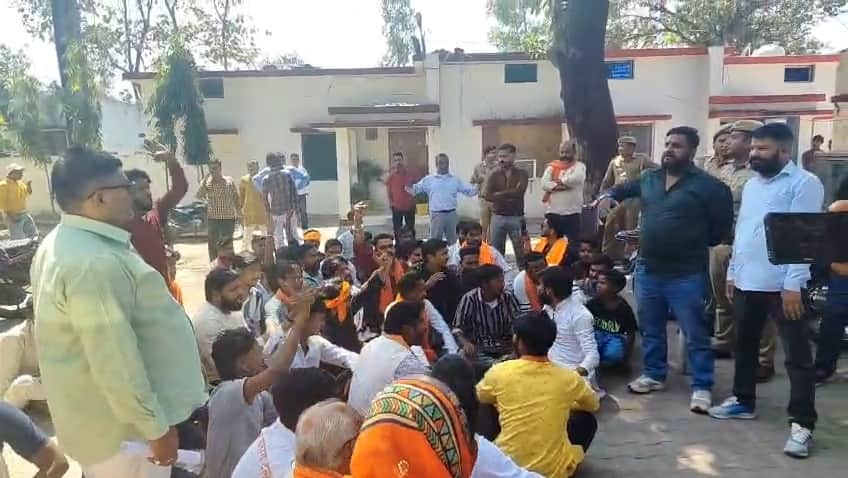 पीड़ित परिवार के साथ निघासन सीओ कार्यालय के बाहर बैठे बजरंगदल के कार्यकर्ता।संवाद