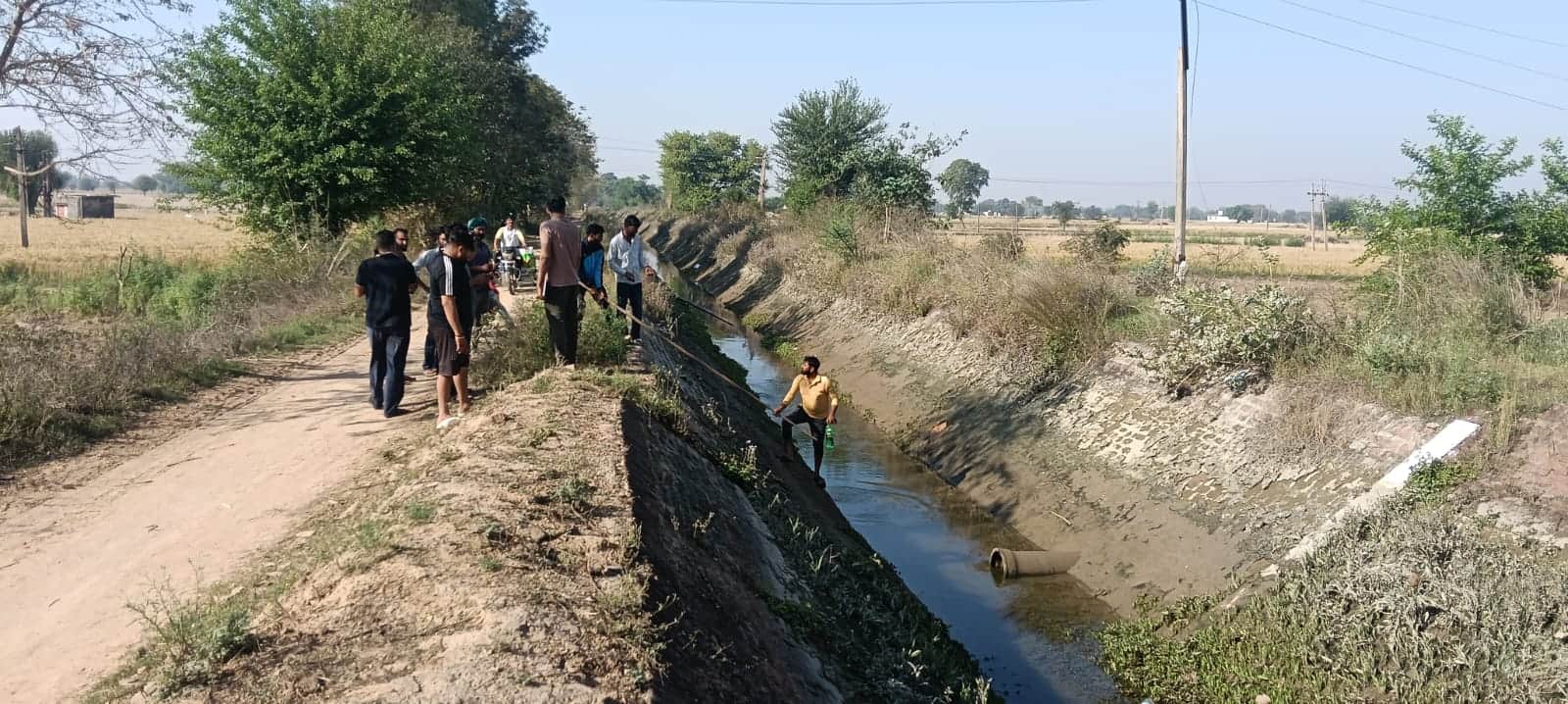 रेवाड़ी। शव को नहर में से निकालते ग्रामीण। संवाद