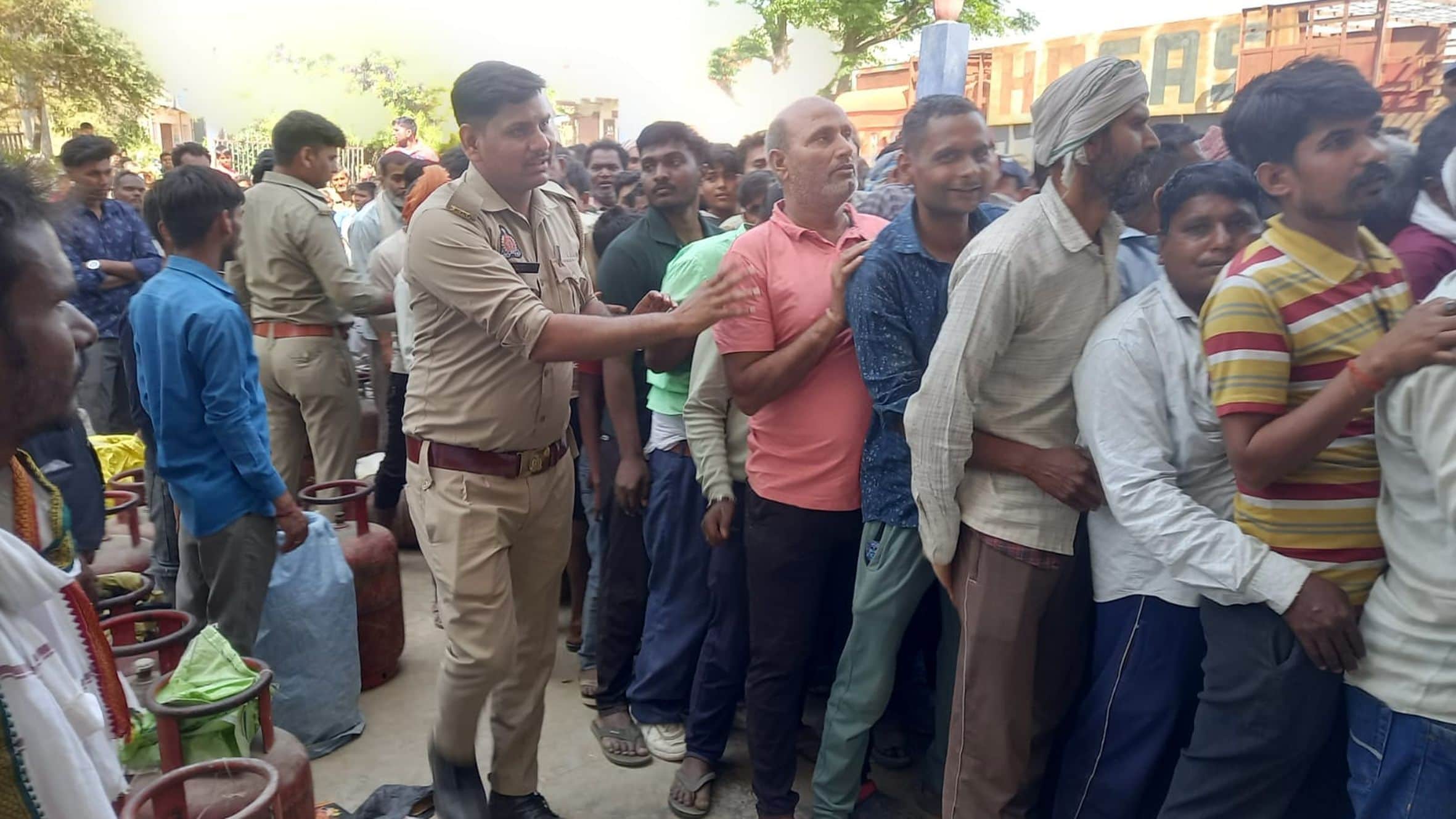 भोजपुर कस्बा स्थित ओम गैस एजेंसी में भीड़ को नियंत्रित करके लाइन में लगवाती पुलिस।