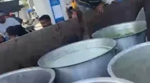 बर्तन में तेल लेने पहुंचे लोग। 