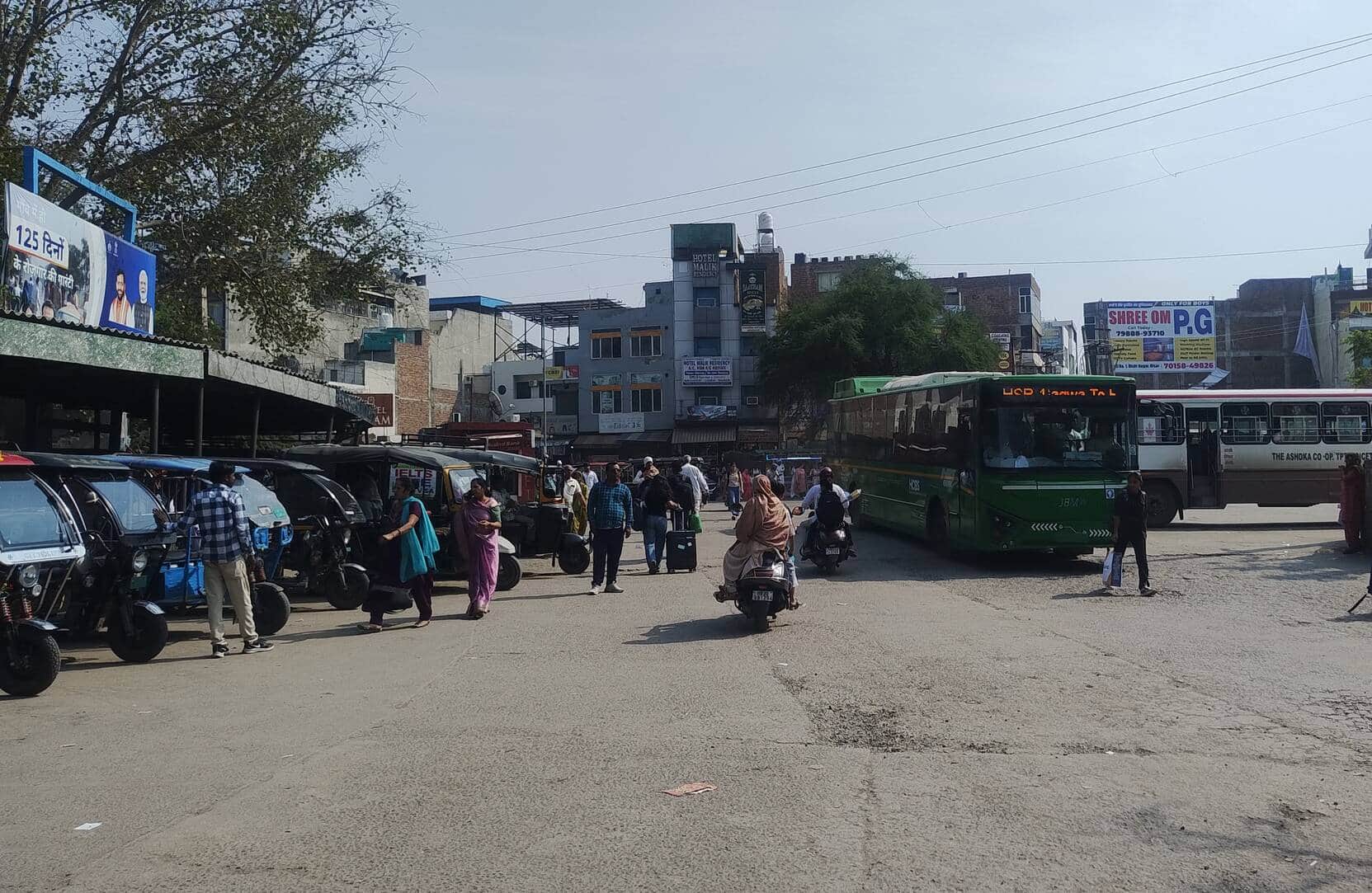 बस स्टैंड पर गेट के आगे खड़े ऑटो रिक्शा।