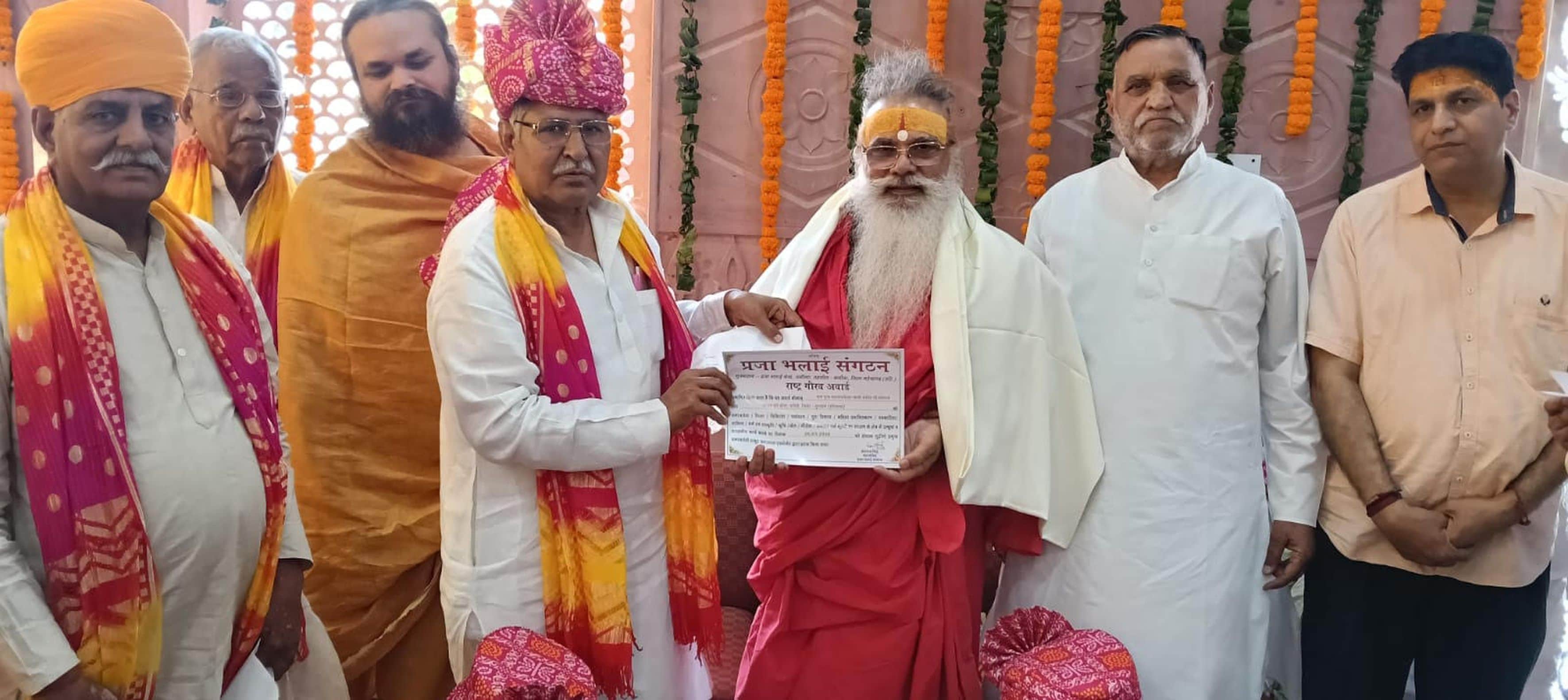 फोटो संख्या:60 महामंडलेश्वर स्वामी धर्मदेव को राष्ट्र गौरव अवार्ड से सम्मानित करते हुए अतरलाल ए