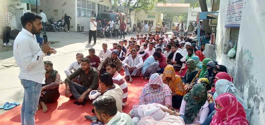 फोटो :  सोनीपत नगर निगम कार्यालय के गेट पर धरने पर बैठे संविदा सफाई कर्मी। स्रोत: संगठन