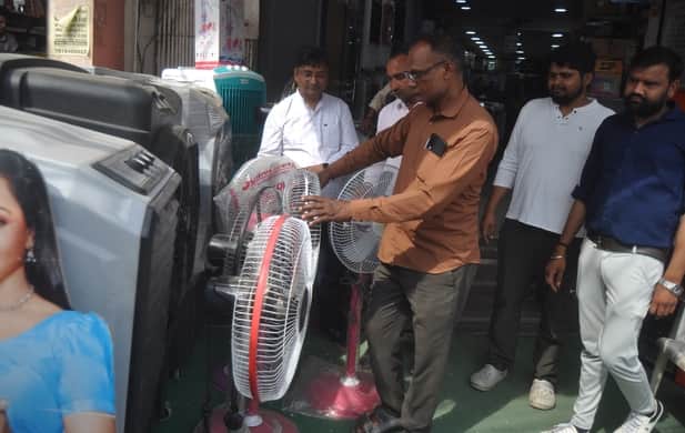 गढ़ रोड पर दुकान से कूलर पंखे खरीदते लोग। संवाद