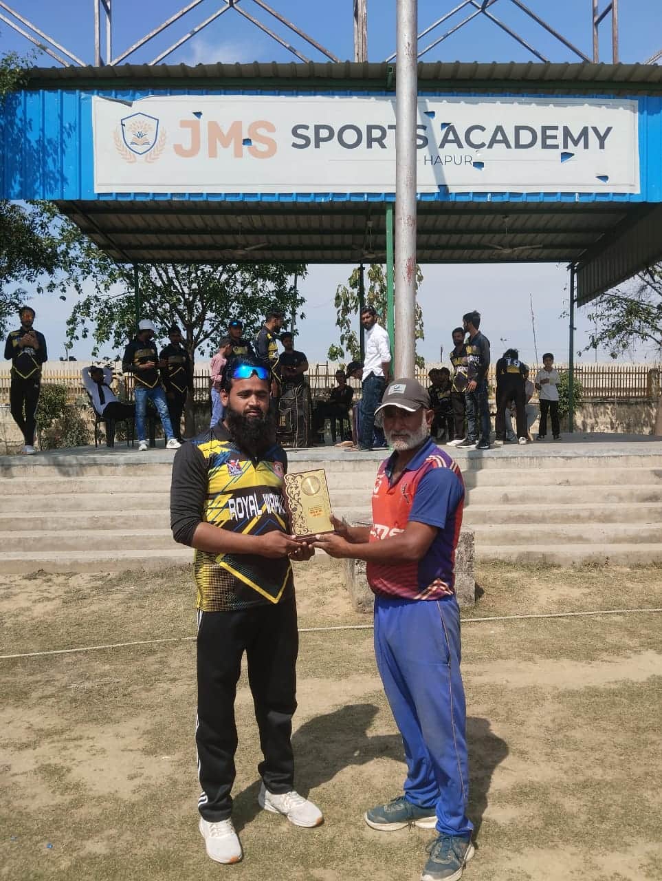 जेएमएस में क्रिकेट मैच के खिलाड़ी को सम्मानित करते कोच। स्रोत अकादमी