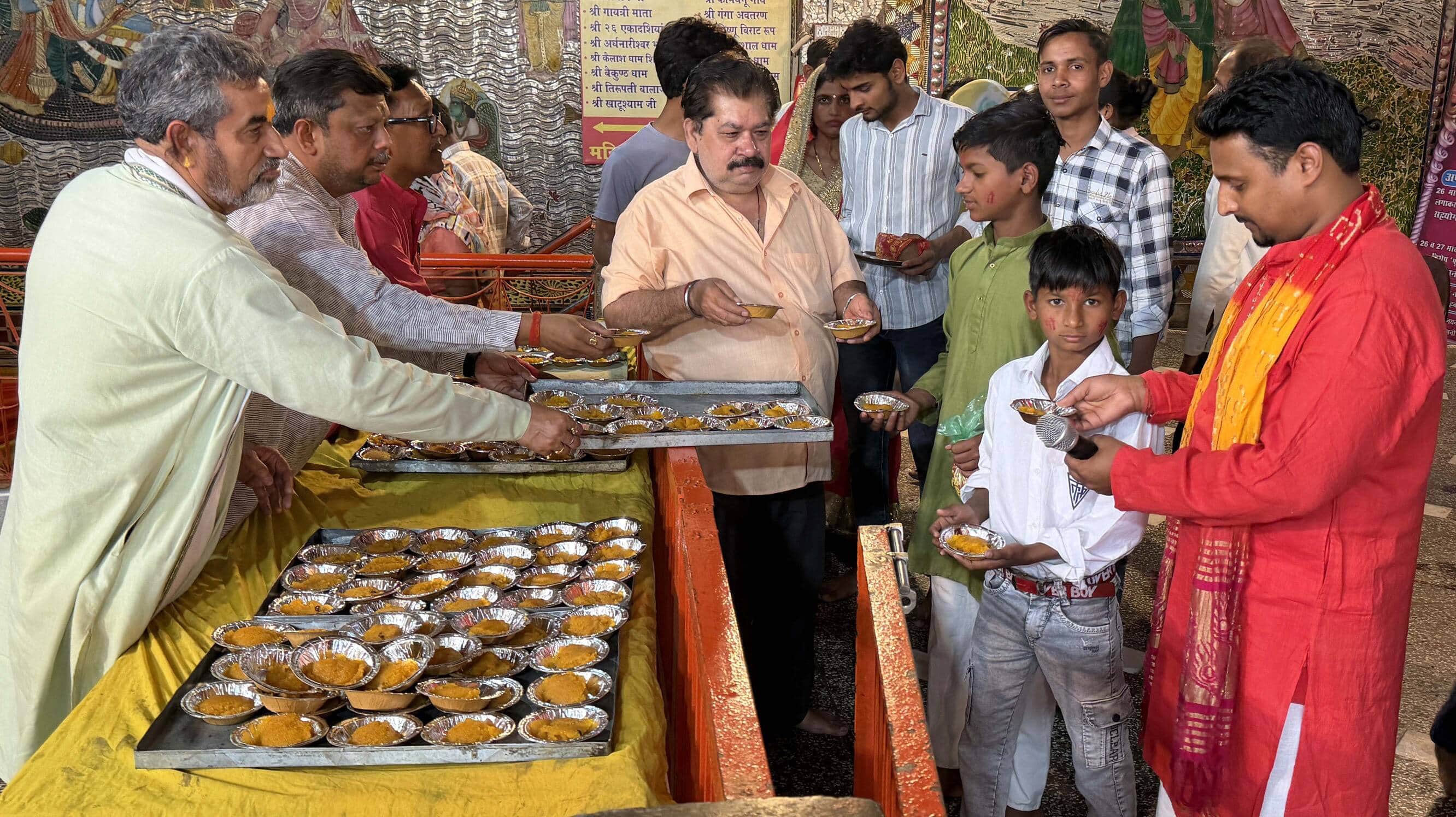 खुर्जा नव दुर्गा शक्ति मंदिर में हलवे का प्रसाद वितरित करते लोग। संवाद