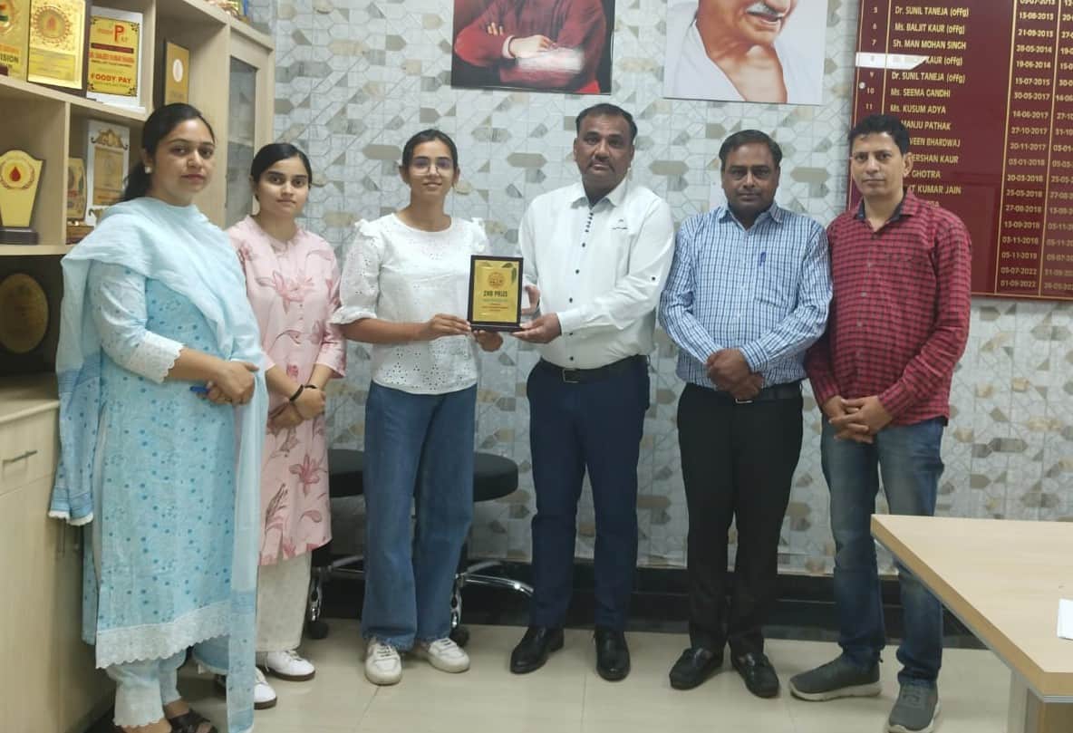 प्रतियोगिता की विजेता छात्रा को सम्मानित करता स्टाफ। संस्थान