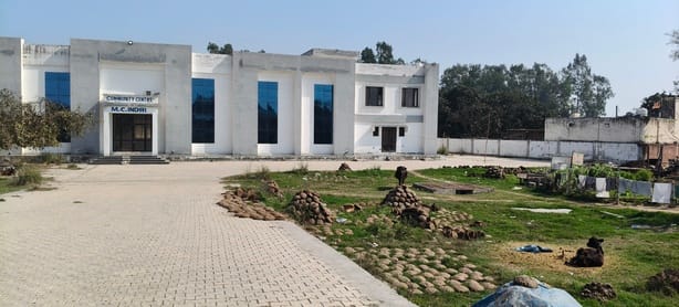 A new community building worth 4.50 crores has been converted into a stable. Animals are tied up, and people have piled up cow dung cakes.