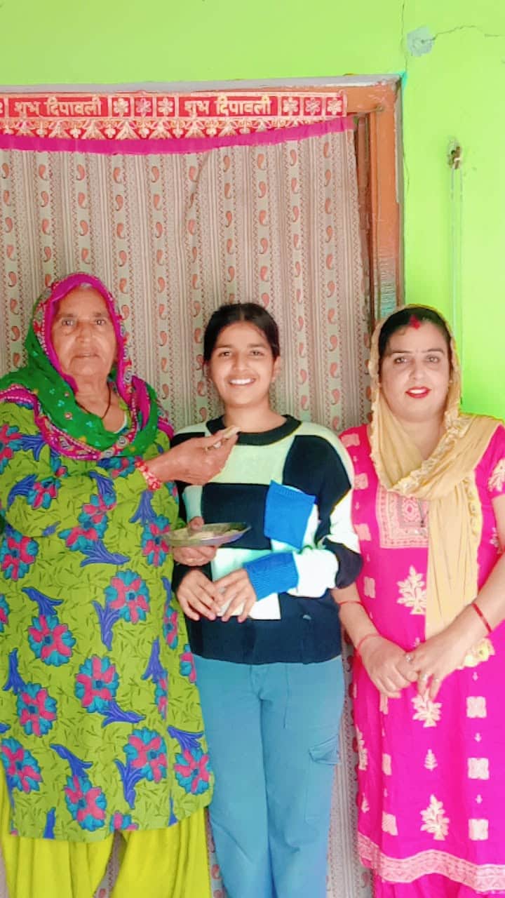 26jjrp19- अमर उजाला ओलंपियाड में टॉप करने वाली तानिया को मिठाई खिलाते परिजन। स्रोत-परिजन