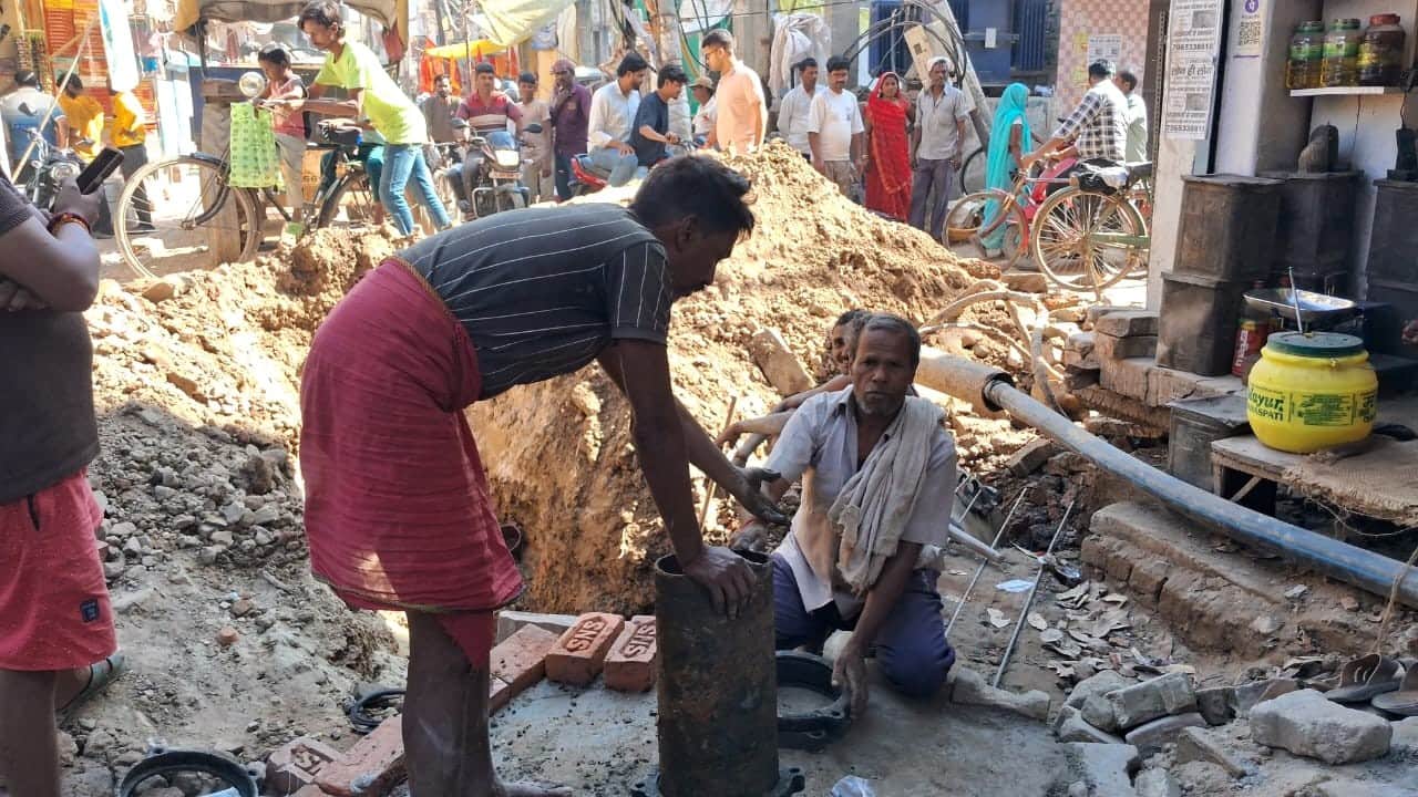 गोपीगंज छोटी चौमुहानी पर टूटा पाइप ठीक करते पालिकाकर्मी। संवाद