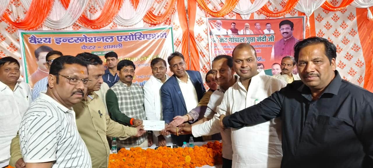 झिंझाना में व्यापारी को चेक देते कैबिनेट मंत्री नंद गोपाल गुप्ता। संवाद