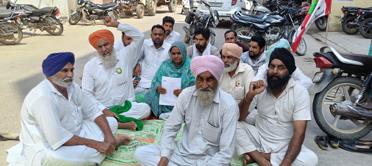 कालांवाली में बीमा क्लेम को लेकर बैंक के बाहर धरने पर बैठे किसान। 