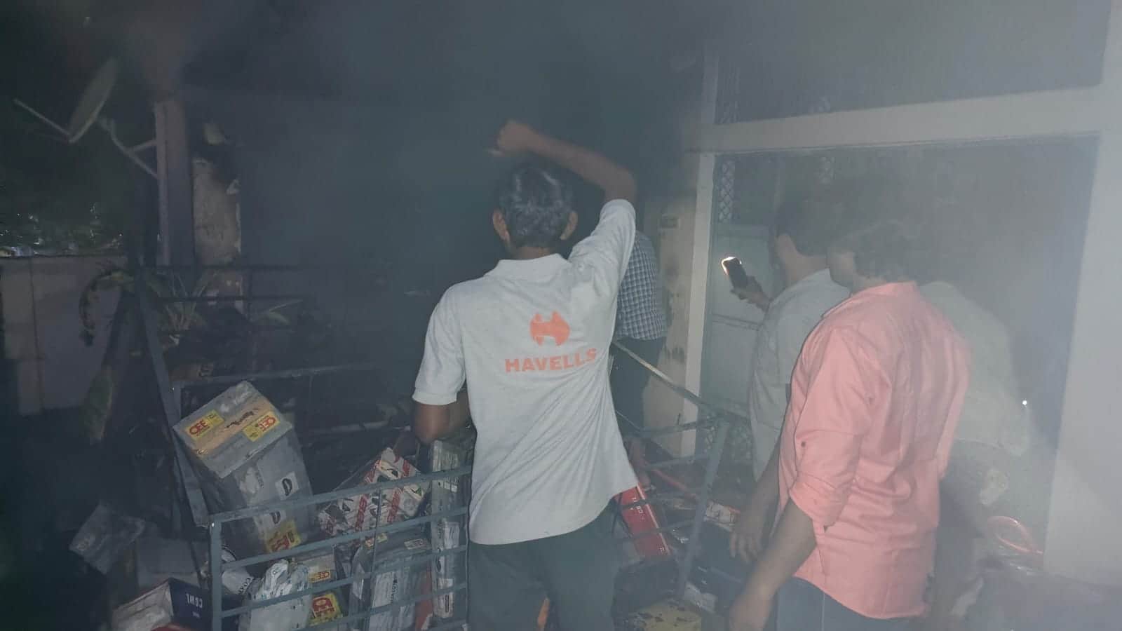 करछना के साधु कुटी चौराहे के पास मकान में लगी आग बुझाते हुए लोग