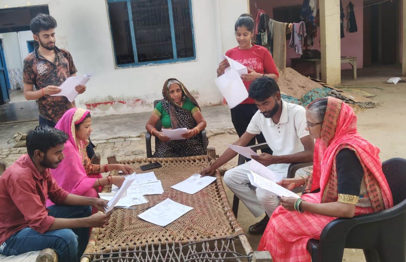 कुड़वार में नया मतदाता बनाने का फाॅर्म देखते लोग।