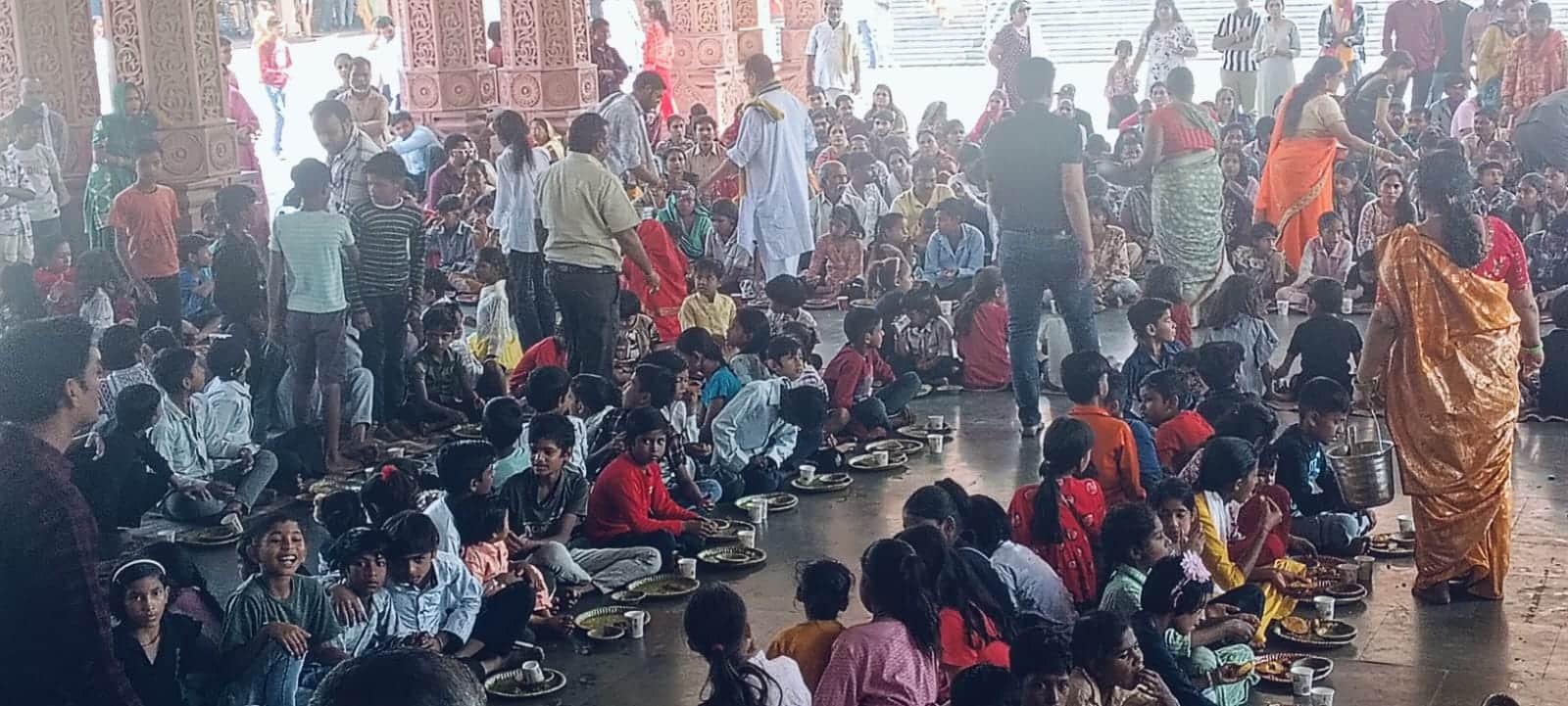 श्री कृष्ण जन्मभूमि में प्रसाद ग्रहण करते लोग। 