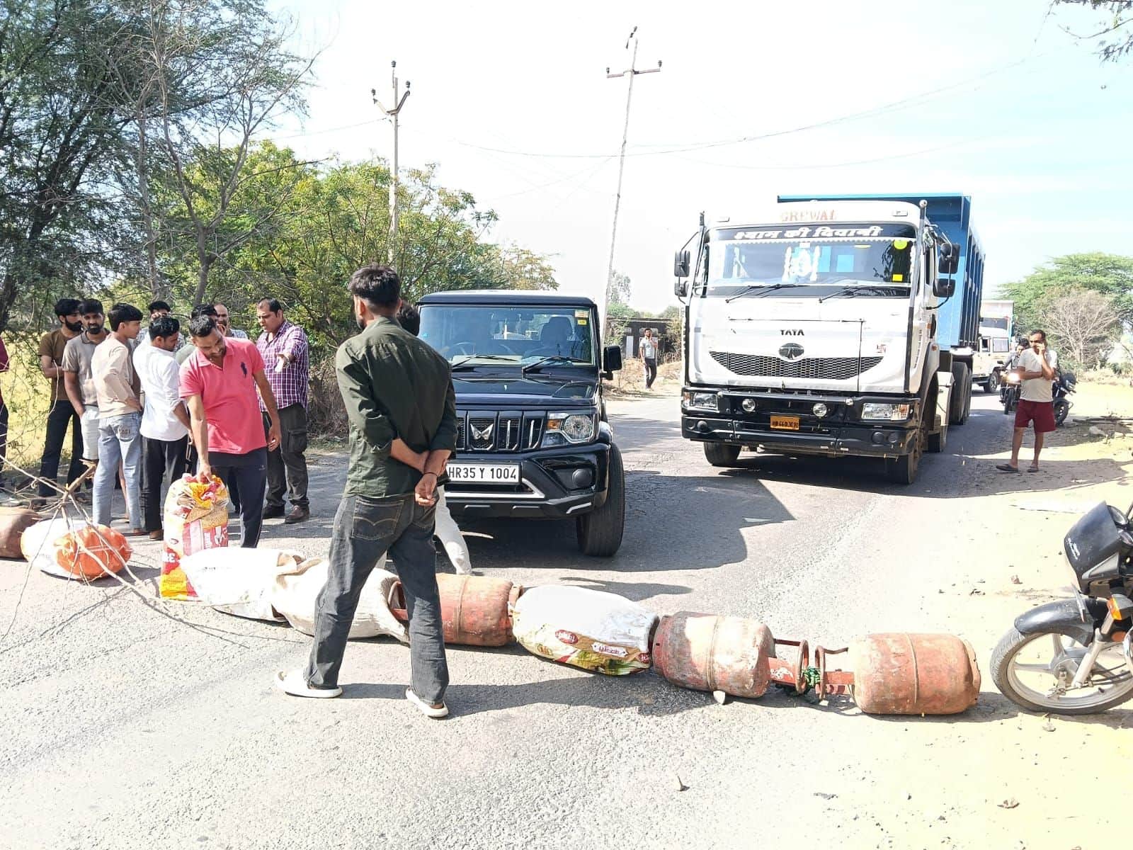 फोटो नंबर-16निजामपुर में सिलिंडर सड़क पर रखकर जाम लगाते ग्रामीण। स्रोत-ग्रामीण