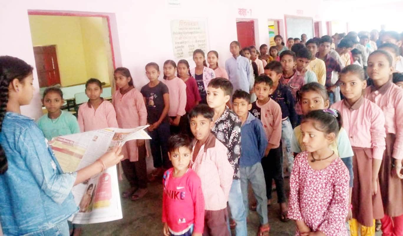 पुवायां के गांव अगौना बुजुर्ग के संविलियन विद्यालय में अमर उजाला की खबरें सुनते बच्चे। संवाद