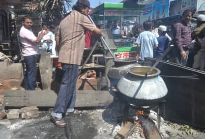 सिकंदर गेट पर गैस सिलिंडर न मिलने के कारण होटल पर लकड़ी जलाकर चूल्हें पर खाना बनाते युवक।संवाद