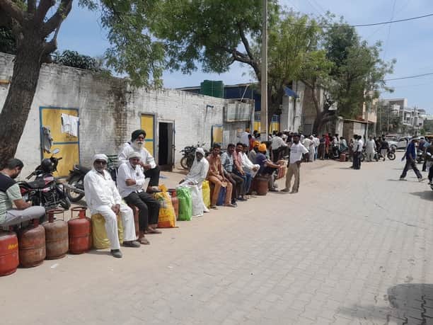 सिरसा की एक गैस एजेंसी के बाहर सिलिंडर के लिए कतार में बैठे लोग। 