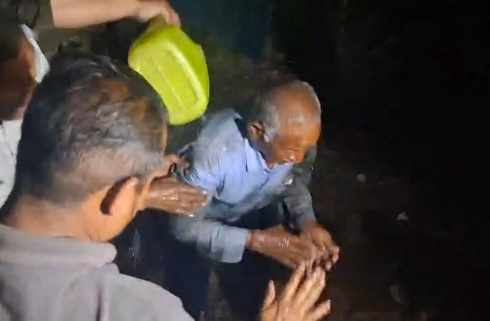 तालाब में गिरे बुजुर्ग को निकालते लोग। स्रोत: वीडियोग्रौब
