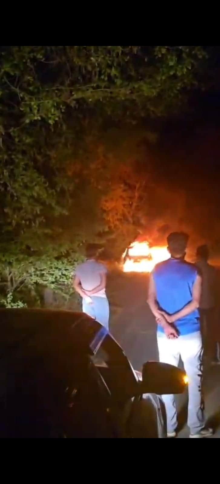 बरवाला के राजली गांव के पास जलती कार देखते लोग। 