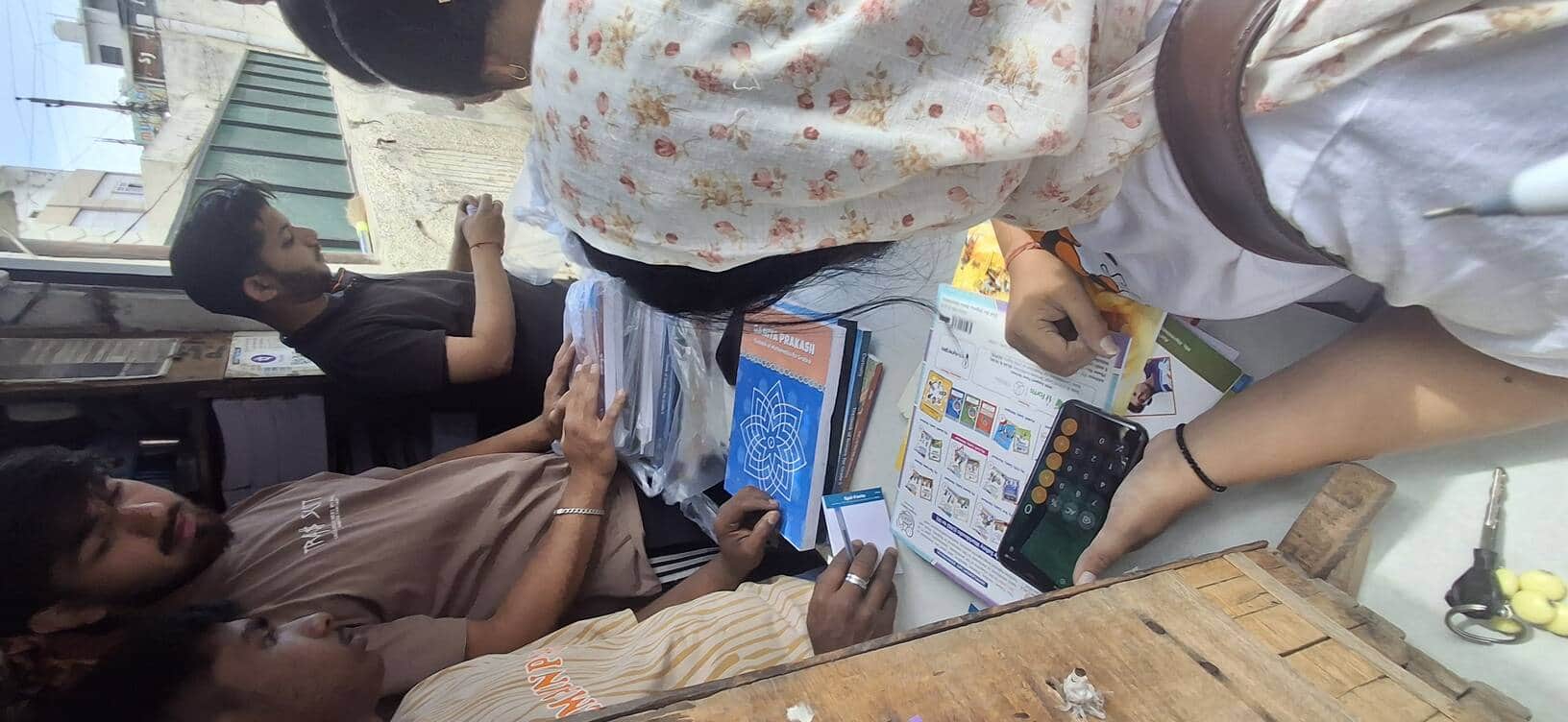 कुंजपुरा रोड स्थित करण बुक शॉप से किताब खरीदते ग्राहक