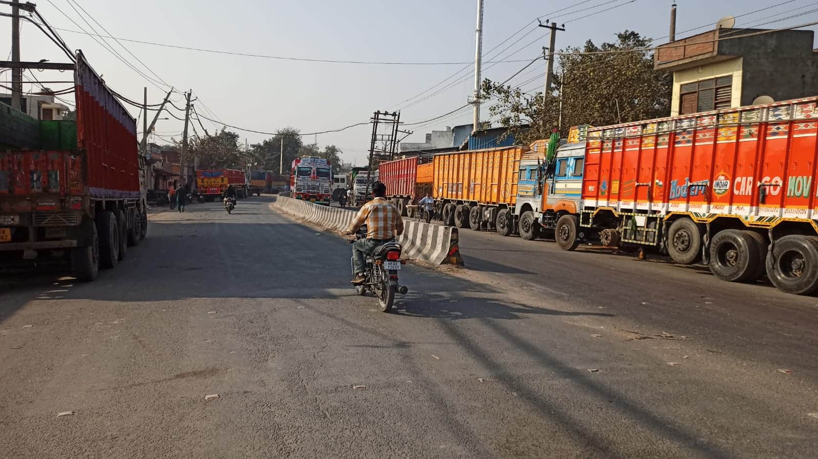 सहारनपुर मार्ग पर सड़क के दोनों और खड़े ट्रांसपोर्टरों के ट्रक। संवाद