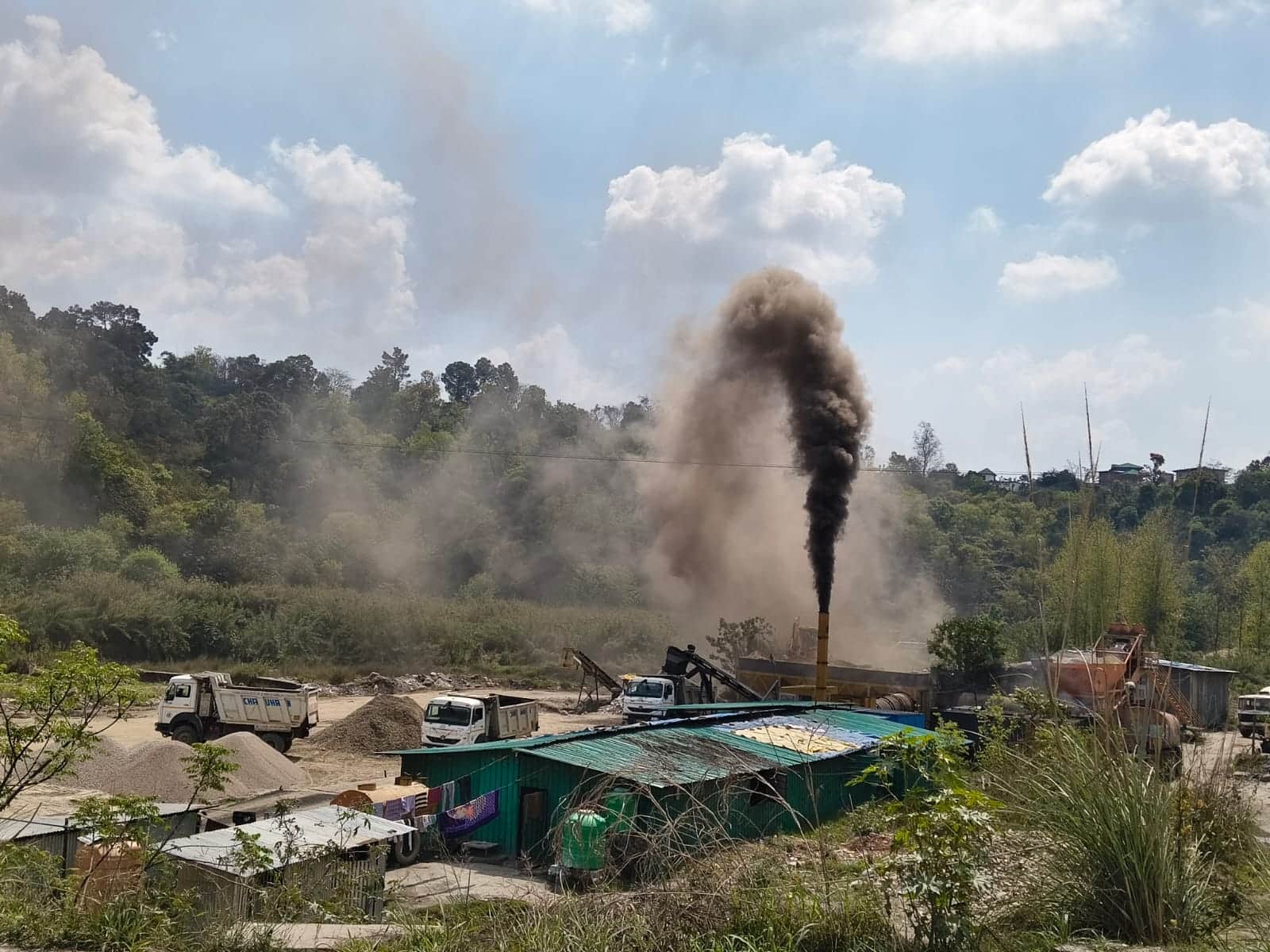 धनेटा के साथ सटी मान खड्ड में लगा हॉट मिक्सर प्लांट जिससे काला गाढ़ा धुआं निकल रहा है कायदे यह 