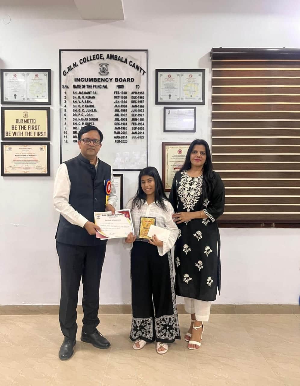 वाद विवाद प्रतियोगिता की विजेता तन्वी साथ में प्रिंसिपल जीएमएन कॉलेज पुरस्कृत करते हुए। कॉलेज