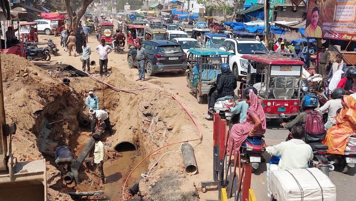 डीग गेट पर सड़क के बीच पाइप लाइन जोड़ते मजदूर व लगा जाम। संवाद